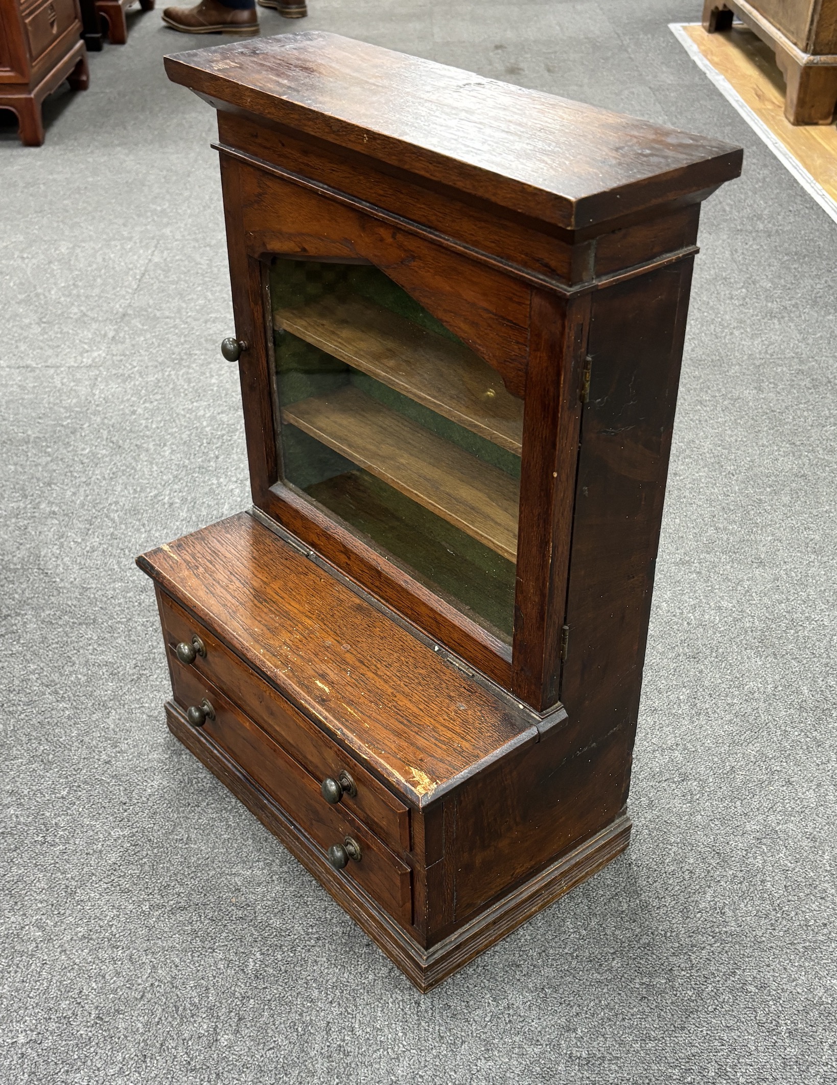 A miniature glazed bookcase with drawers under, height 56cm